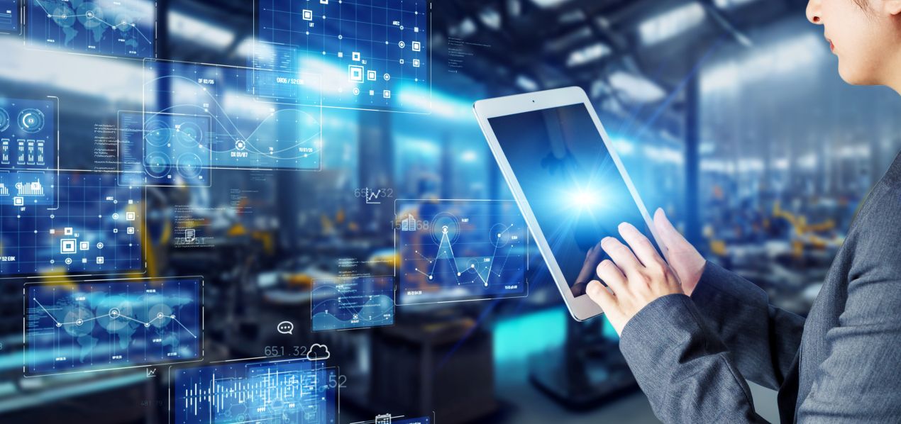Person in Produktionsumgebung nutzt Tablet zur Steuerung von Prozessen mit APS System – digitale Planung und Datenvisualisierung